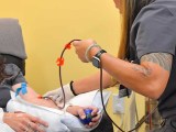 A nurse wiggle the EBOO blood therapy IV line to get the debris flowing.