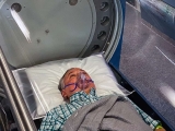Man in hyperbaric oxygen chamber to speed healing.