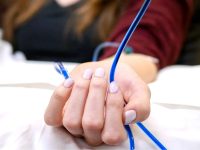 Patient holding the blue Methylene Blue IV line during treatment session.