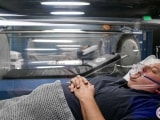 Patient in hyperbaric oxygen therapy chamber resting.